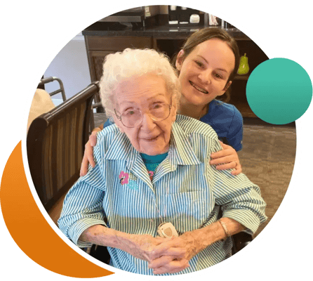 A smiling resident and staff member in a common area