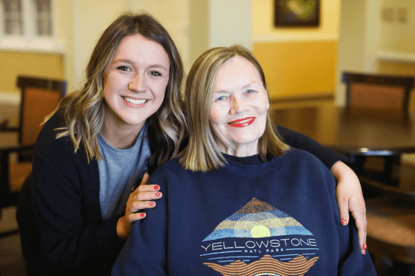 Staff member posing with a resident in a common area