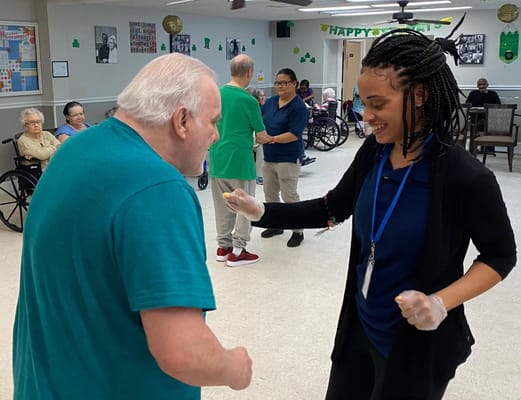 A staff member interacting with a resident during an activity