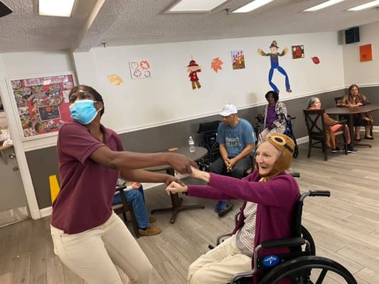 Resident and staff member engaged in a dance activity