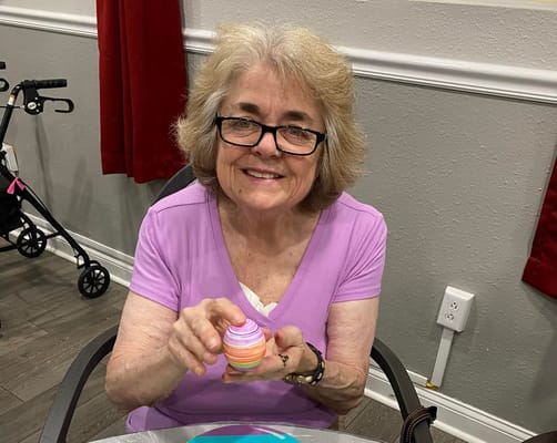 Resident enjoying a colorful dessert in an activity room