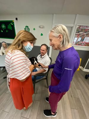 Residents interacting with a therapy dog in a common area