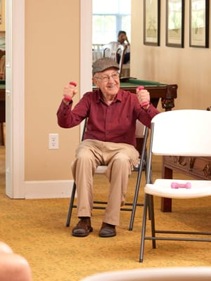 Resident exercising with weights in a common area