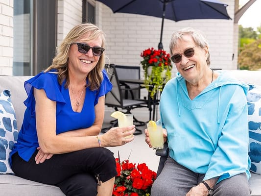 Two women enjoying drinks on an outdoor patio