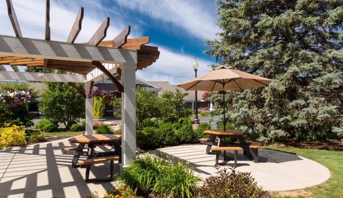 Outdoor seating area with shaded tables and chairs