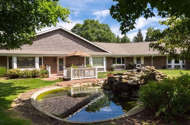 Exterior view of a senior living facility with a pond