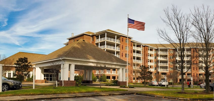 Exterior view of a senior living facility with American flag