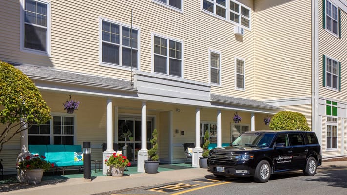 Exterior view of a senior living facility with a vehicle