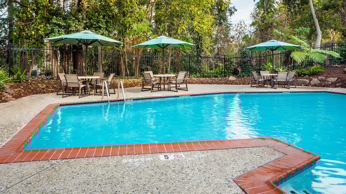 Swimming pool area with tables and umbrellas