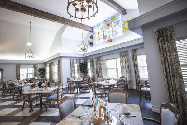 Brightly lit dining room with tables set for meals