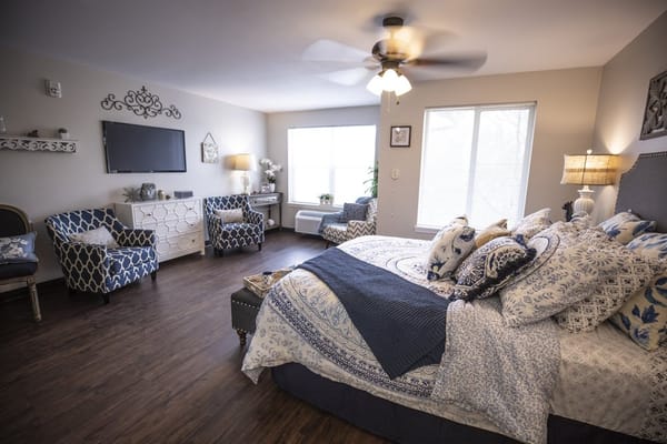 Bright and inviting bedroom with bed, armchairs, and window