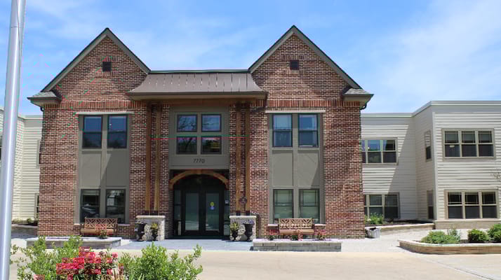 Exterior view of a senior living facility with gardens