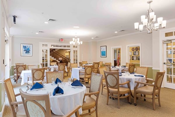 A well-set dining room with tables and chairs in Benchmark Senior Living.