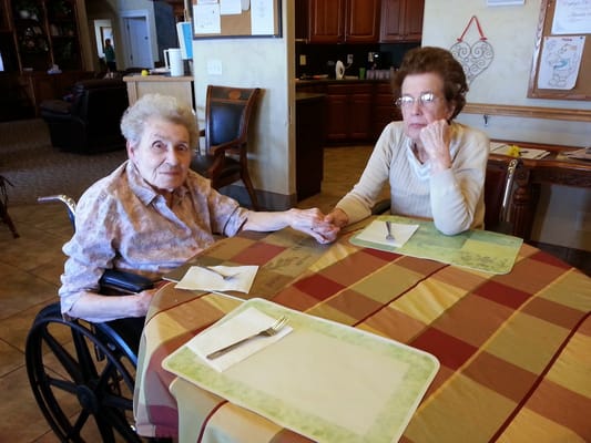 Two residents interacting at a table in the facility