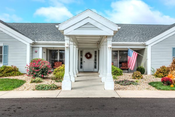 Front entrance of Carriage Court of Grove City featuring a porch and American flag