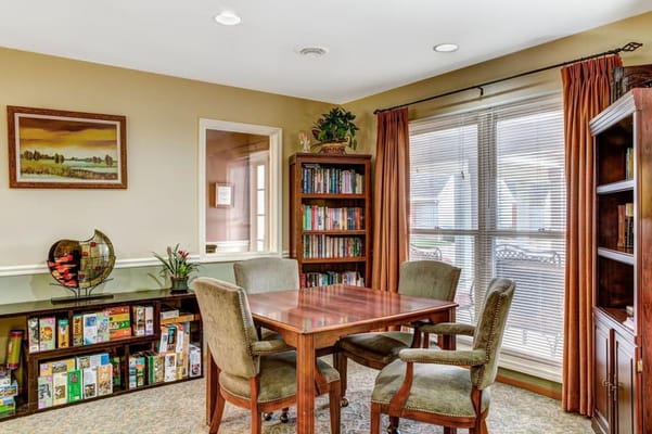 Cozy common area with a wooden table and bookshelves
