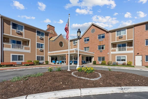 Exterior view of Chapel Hill Senior Living with a flag and flower beds