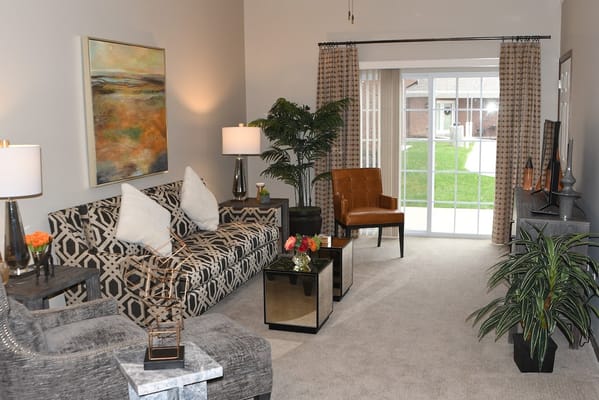 Modern living room with artwork, seating, and plants