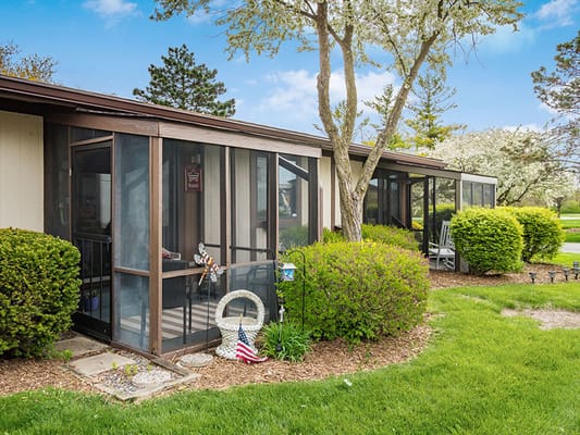 Outdoor patio area with greenery and screened porches