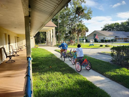Two residents riding tricycles along the pathway