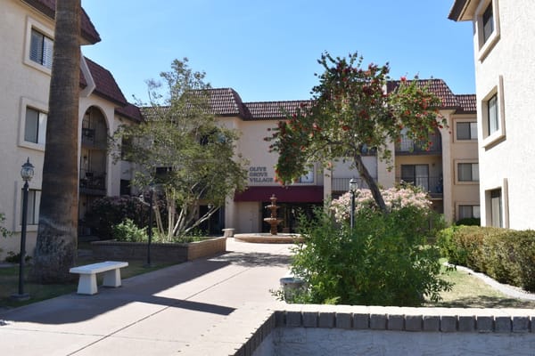 Entrance of Olive Grove Assisted Living with fountain and greenery