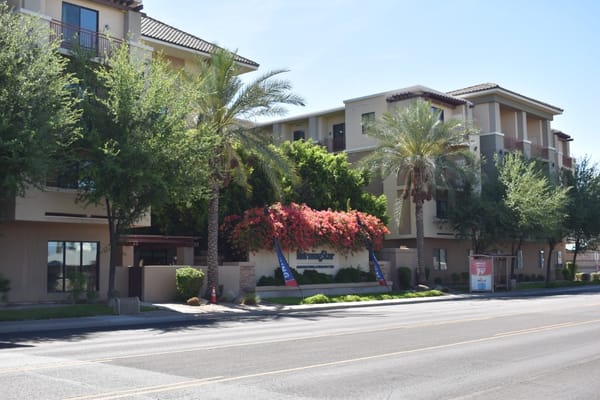 Exterior view of MorningStar Assisted Living & Memory Care building with greenery.