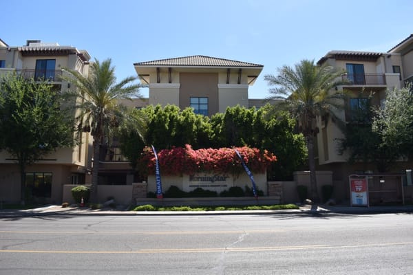 Entrance of MorningStar Assisted Living with flowers and palm trees