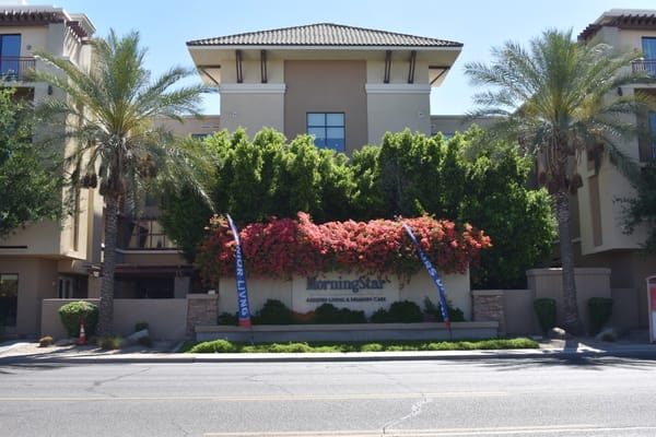 Entrance of MorningStar Assisted Living with flowers and palm trees