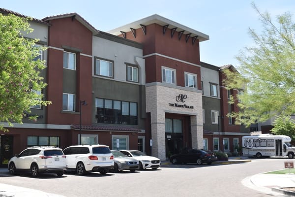 Front view of Manor Village at Desert Ridge with parked cars.