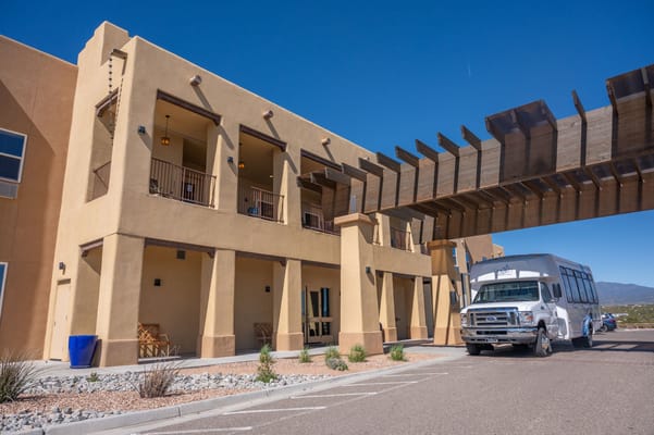 Exterior view of a senior living facility with shuttle bus