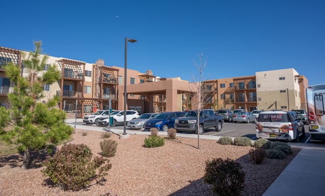Exterior of Las Soleras Senior Living with parking area and landscaping.