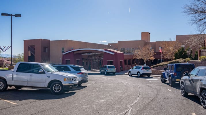The entrance of The Montecito Santa Fé surrounded by parked cars.