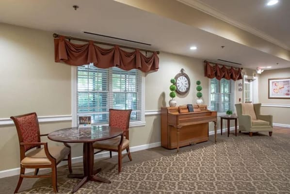 A cozy common area with seating and a piano