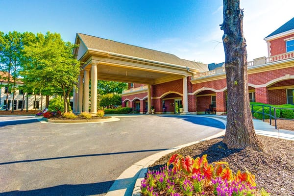 Welcoming entrance of Dunwoody Place with lush landscaping and a covered entryway.