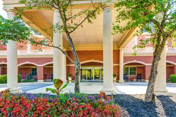 Welcoming entrance featuring columns and colorful flowers at Dunwoody Place.