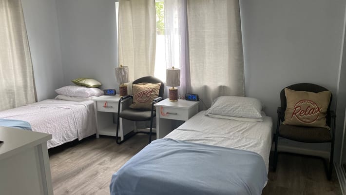 A cozy shared room with two beds and lamps