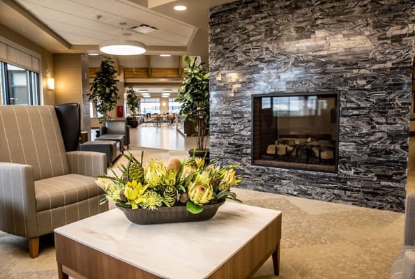 Lobby area featuring comfortable seating, a floral arrangement, and a fireplace.