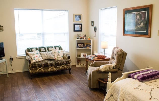 A cozy living room featuring a couch, armchair, and a bookshelf.