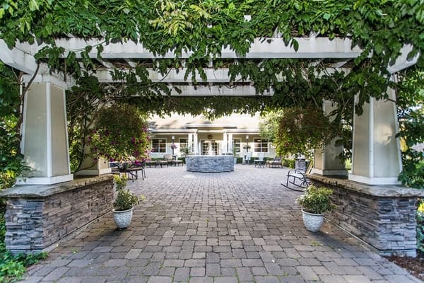 A serene courtyard with a stone fountain and lush greenery at Garden Way Retirement Community.