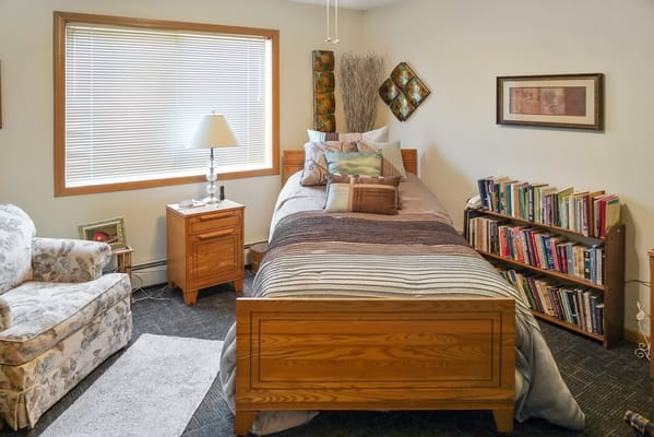 Cozy private bedroom with a bed and bookshelf