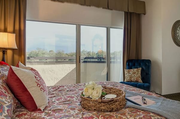 Cozy resident room with floral bedding and balcony view