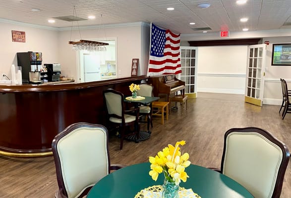 Inviting common area with seating, piano, and American flag.