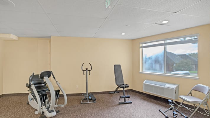 Gym equipment in a fitness room with a large window