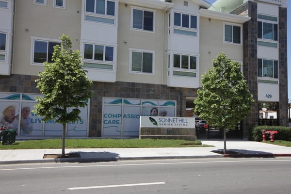 Sign and exterior of Sonnet Hill Senior Living with trees in front