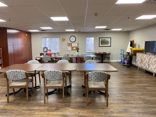 Spacious activity room with tables and chairs