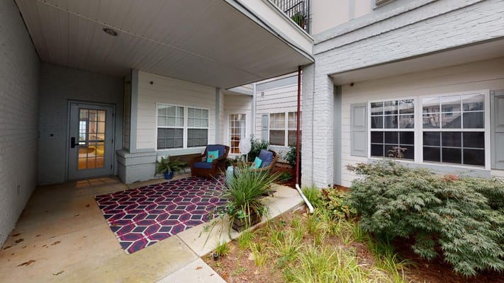Outdoor seating area with plants and colorful rug