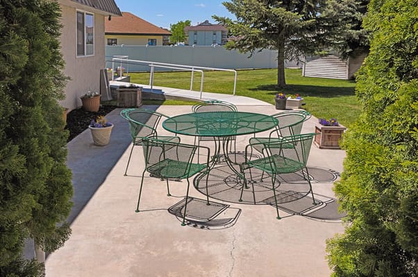 Outdoor seating area with green chairs and table