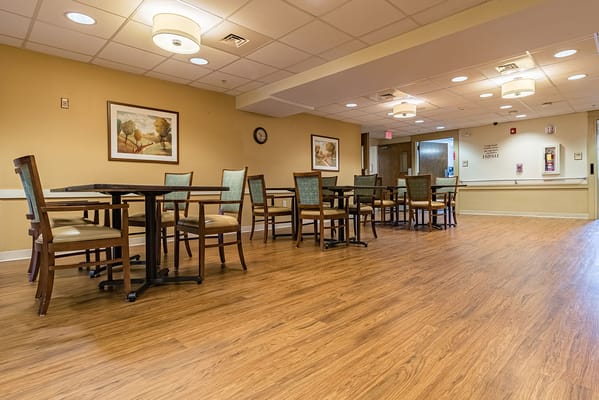 Common area with tables and chairs in warm lighting