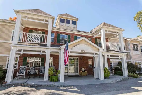 Front entrance of Park Place of Fountain City with an American flag and seating area