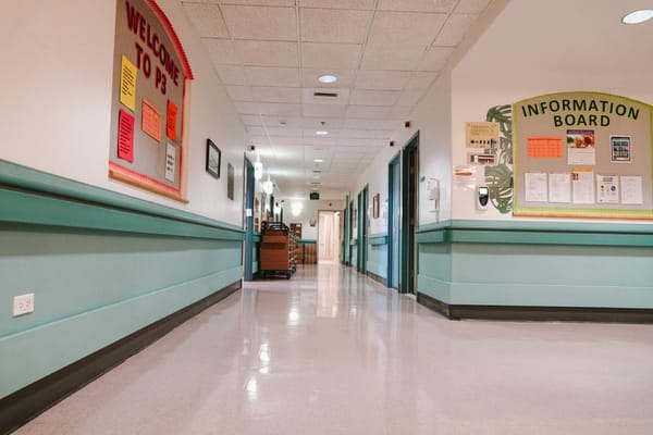 A long, well-lit hallway with information boards and colorful welcome signs